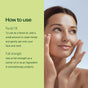 A woman with clear skin gently touches her face next to text instructions on how to use Plant Therapy’s Younger Glo Facial Oil as an effective anti-aging oil and full-strength facial moisturizer, with a green background on the left side.