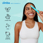 A smiling woman in a white tank top holds the Zimba On-the-Go Kit near her eye. Icons and text read: vegan, cruelty-free, clean, and reduced sensitivity. The background is light blue with star graphics.