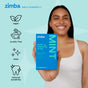 A smiling person in a white tank top holds a blue box of Zimba Whitening Strips. Icons and text on the left highlight features: vegan, cruelty-free, clean formula, reduced sensitivity, and effective for whiter teeth.