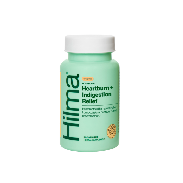 A mint green bottle of Hilma Heartburn + Indigestion Relief herbal supplement with 50 capsules, featuring white and yellow labeling and black text on a plain white background.