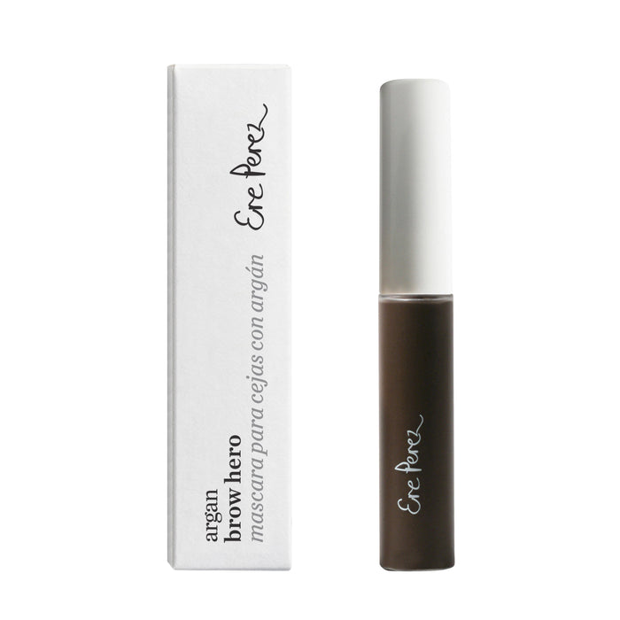 A tube of Ere Perez Argan Brow Hero mascara with a white cap is standing next to its white rectangular box, both featuring the brands logo and product name in black cursive text.