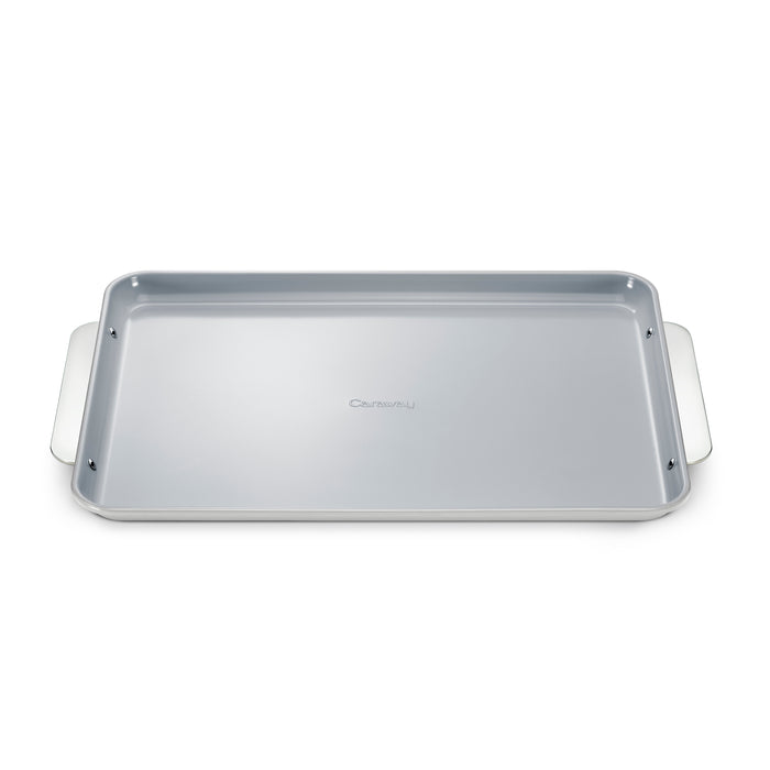 A rectangular silver baking sheet with raised edges and two wide handles on each side, placed on a white background.