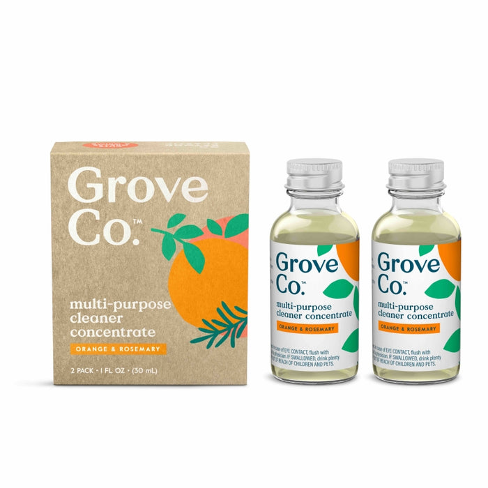 Two bottles of Grove Co. multi-purpose cleaner concentrate in orange and rosemary scent are shown next to a cardboard box with an orange fruit and green leaves design. The bottles have clear liquid and matching labels.