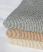 Three folded Adult Popcorn Blanket - Cream blankets with a textured, waffle-knit pattern in shades of grey, tan, and cream.