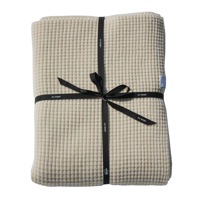 Cream-colored, plant-dyed Adult Popcorn Blanket - Cream folded and tied with a black ribbon.