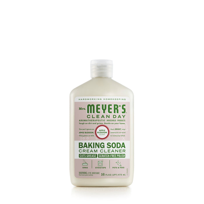 A bottle of Mrs. Meyer’s Clean Day Baking Soda Cream Cleaner with Apple & Rhubarb scent, featuring a white label, green and red text, and descriptions of product use and benefits. The bottle holds 16 fl oz (473 mL).