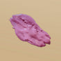A smear of Anima Mundi’s ROSE Face Mask, Detoxify + Hydrate—a thick, glossy pink formula—rests on a plain beige background.