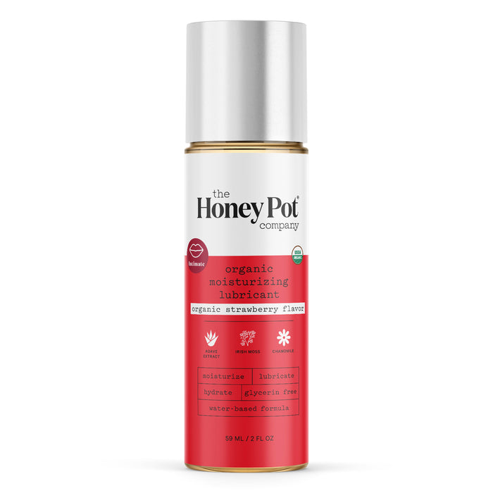 A bottle of The Honey Pot Company organic moisturizing lubricant in strawberry flavor, featuring a red and white label with gold accents and product details. The bottle contains 59 mL (2 fl oz).