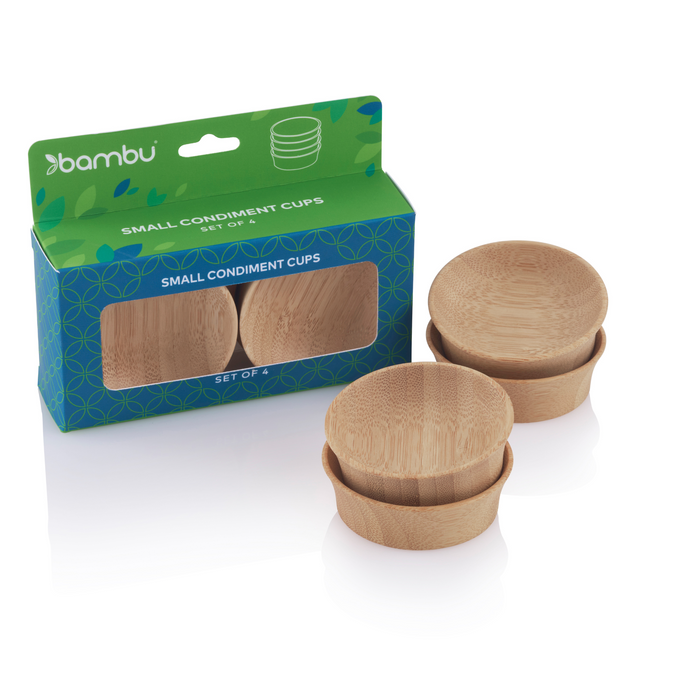 A set of four small round bamboo condiment cups, two displayed outside and two inside green-blue packaging labeled bambu small condiment cups. The box has a window showing the cups inside.