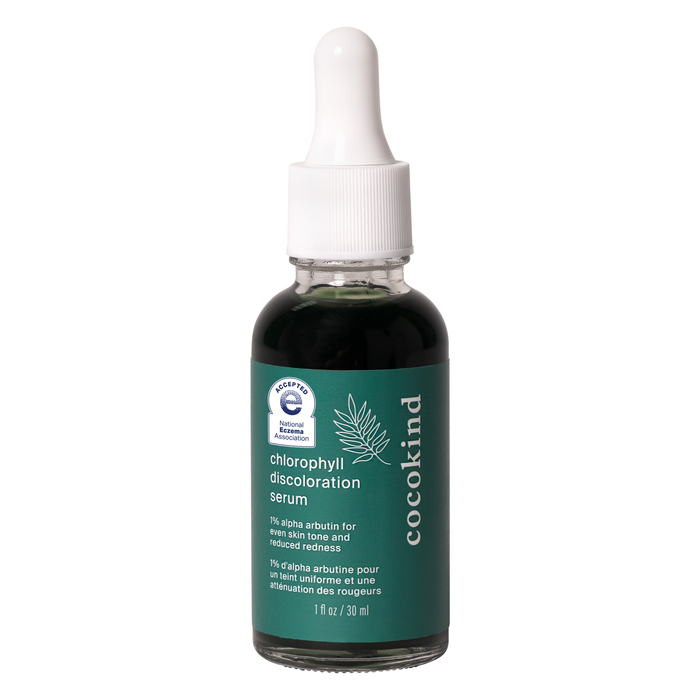 A glass dropper bottle of Cocokind Chlorophyll Discoloration Serum with a green label and white dropper cap, containing dark green liquid. The label displays product details and certifications.