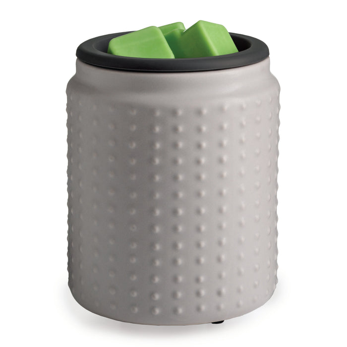 A textured, cylindrical, light gray container with a black rim, holding two green, rectangular objects inside.
