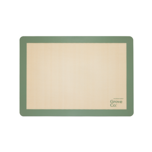 The Silicone Baking Mat from Grove Co. is rectangular and eco-friendly, with a beige center and green border. Grove Co. is elegantly printed on the bottom right, blending style and functionality into your baking routine.