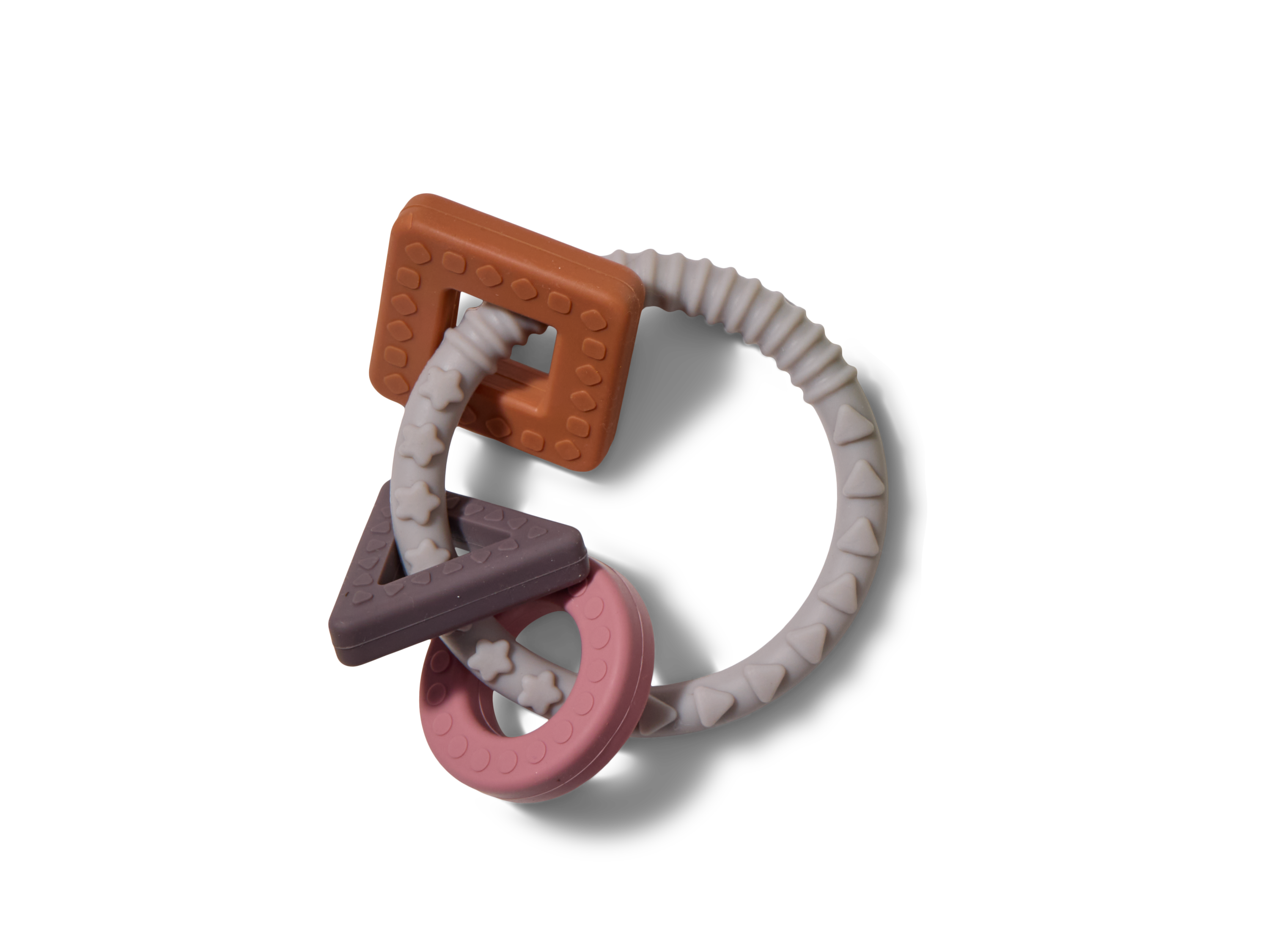 A baby teething toy with a textured white ring holding three colorful silicone shapes: a brown square, a pink circle, and a purple triangle, all designed for easy gripping and chewing.