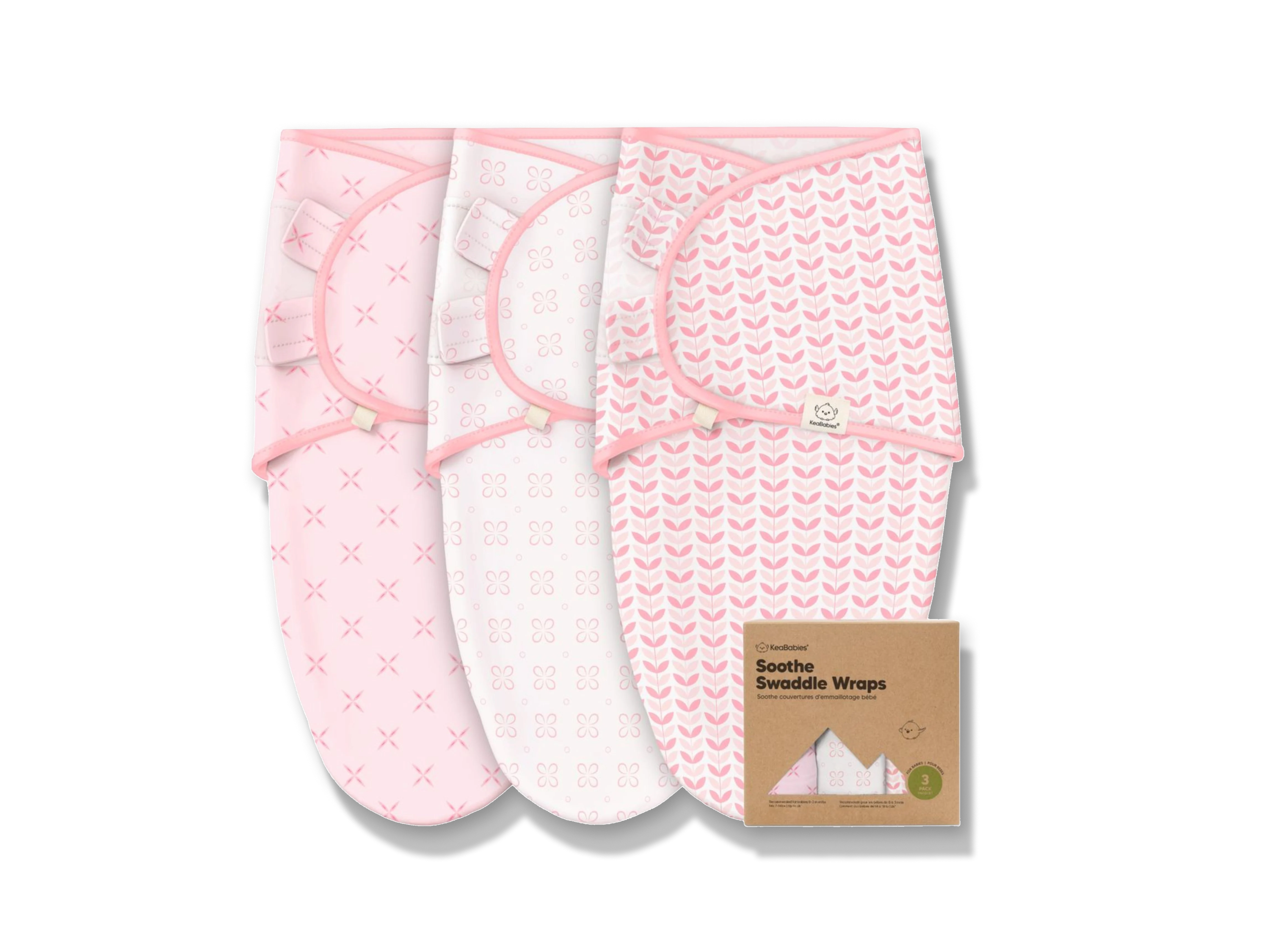 Three pink and white baby swaddle wraps with different patterns—crosses, clovers, and chevrons—are displayed side by side, with a brown cardboard box labeled Soothe Swaddle Wraps in front of them.