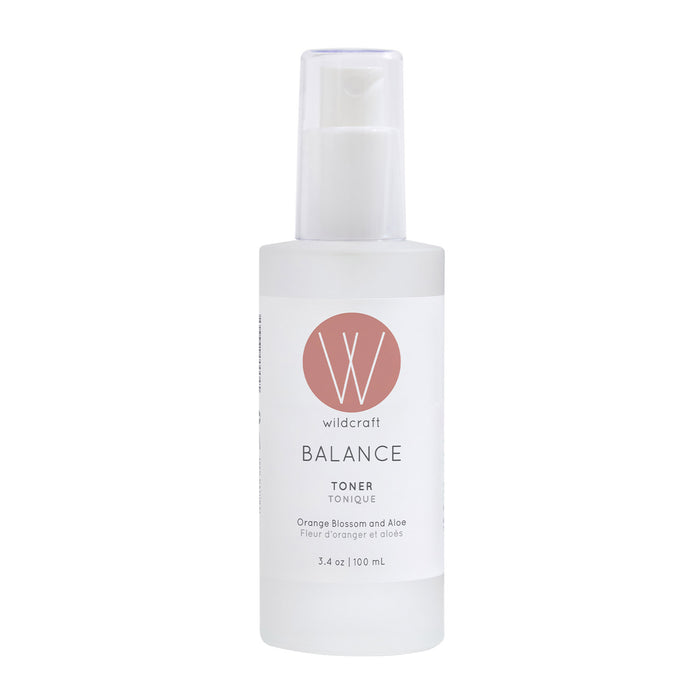 Wildcraft Balance Toner is an alcohol-free essence in a 100 mL clear plastic bottle with a white pump, white label, and pink circle logo. Made with neroli, aloe vera, and orange blossom for refreshed, balanced skin.
