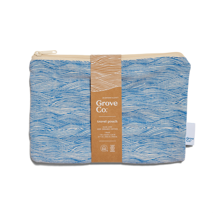 A Grove Co. travel pouch made from organic cotton, featuring a blue and white wavy line pattern, a beige zipper, and a brown paper label wrapped around the center.