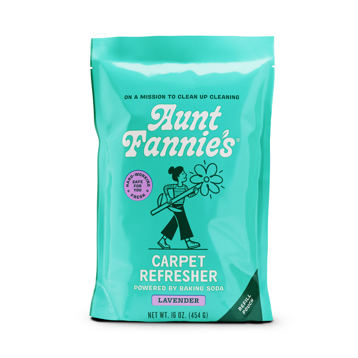 A turquoise pouch of Aunt Fannies Carpet Refresher, featuring a cartoon woman with a broom, lavender scent label, and text stating it is powered by baking soda and safe for people and pets. Net weight is 16 oz (454 g).