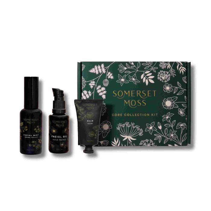 Somerset Moss Core Collection Kit with green floral box and three skincare products: a facial mist in a spray bottle, a facial oil in a pump bottle, and a balm in a small tube, all arranged side by side.