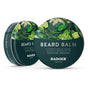 Two round tins of Badger Balm Organic Beard Balm Tin - Condition & Tame, each with green botanical designs featuring pears, limes, and leaves. The front tin reads “Condition & Tame, Certified Organic, Badger Balm, 56g/2oz.” This certified organic beard balm nourishes facial hair with natural ingredients while providing effective styling.