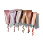 Six metallic tubes of RMS Beauty Eyelights cream eyeshadow in various shades, each with a swirl of shimmery product flowing out, arranged on a white background.