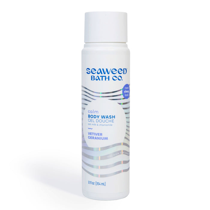 A white bottle of Seaweed Bath Co. Calm Body Wash with vetiver and geranium, displaying blue and silver text and wavy silver lines. The bottle is 12 fl oz (354 mL) and mentions the scent as vetiver geranium.