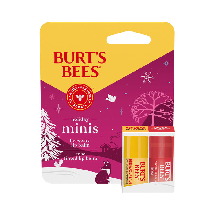 A Burt’s Bees holiday minis pack featuring beeswax lip balm and rose tinted lip balm, displayed in yellow and red tubes against festive packaging with winter trees, birds, and snowflakes.