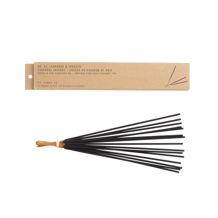 A bundle of black charcoal incense sticks tied with tan twine, shown below a rectangular cardboard box labeled No. 04: Teakwood & Tobacco Charcoal Incense from PF Candle Co.
