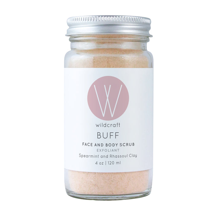 A glass jar with a metal lid containing pink face and body scrub. The label reads wildcraft BUFF Face and Body Scrub Exfoliant, Spearmint and Rhassoul Clay, 4 oz | 120 ml with a large W logo above the text.