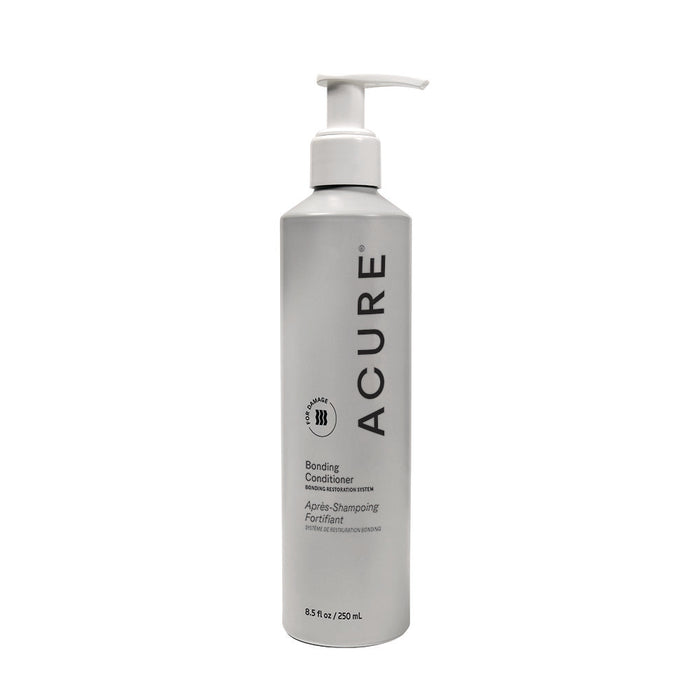 A silver 8.5 fl oz Acure Bonding Conditioner bottle with a white pump features black label text and logo, and contains cocoa butter for improved manageability and hair that feels soft and supple.
