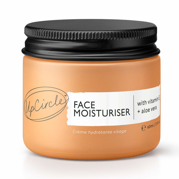 A peach-colored jar of UpCircle Face Moisturiser with a black lid, labeled as containing vitamin E and aloe vera, 60ml size. The text is in English and French.