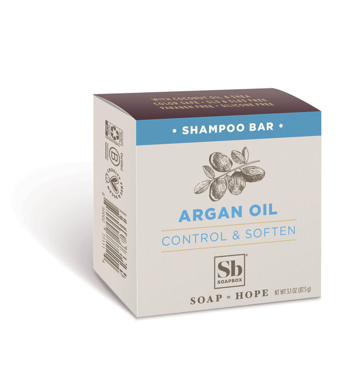 A box of Soapbox shampoo bar with argan oil, labeled “Control & Soften.” The packaging is beige with blue accents and an illustration of argan nuts, and the net weight is 3.0 oz (85 g).
