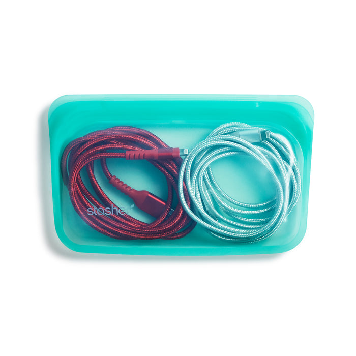 A turquoise Stasher silicone pouch containing a coiled red charging cable and a coiled light blue charging cable on a white background.