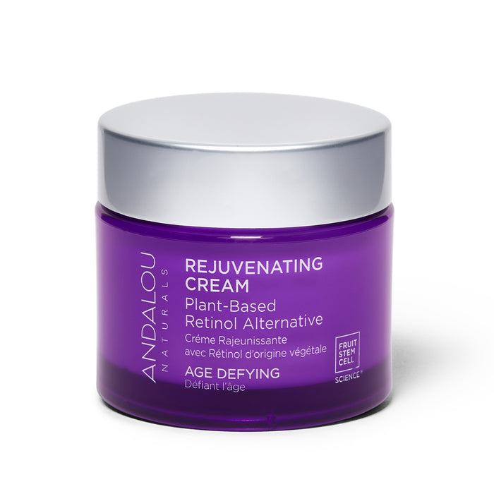 A purple jar of Andalou Naturals Rejuvenating Cream with plant-based retinol alternative, labeled as age defying and featuring fruit stem cell science. The jar has a silver lid and white text.