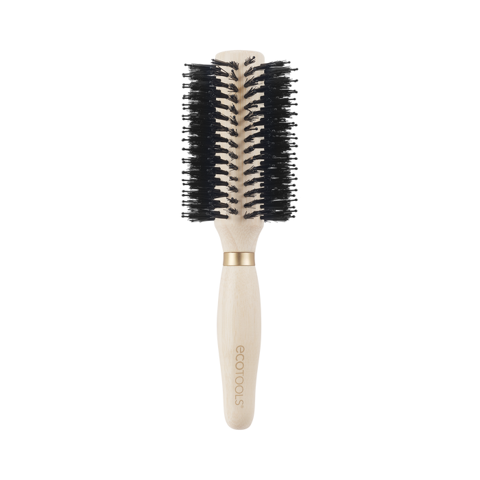 A round hairbrush with black bristles and a light wooden handle, featuring a gold band near the brush head. The handle is engraved with the brand name ecotools.