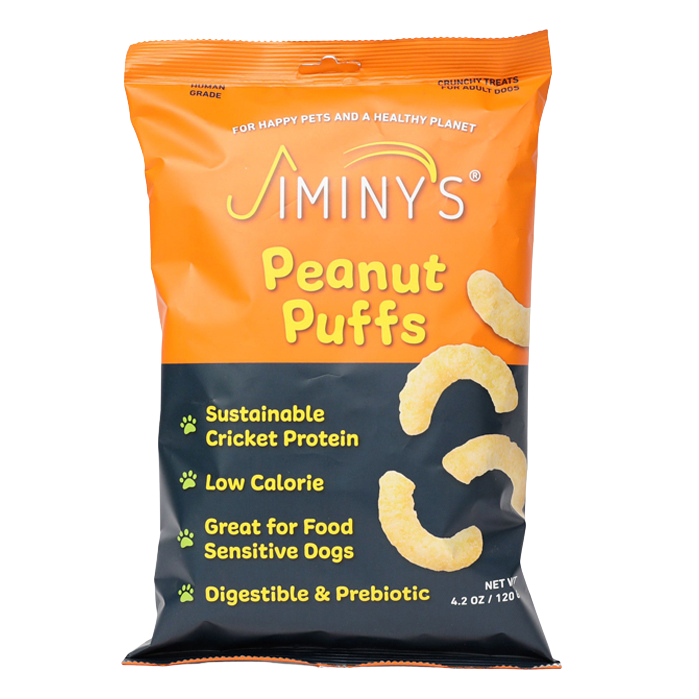 A bag of Jiminys Peanut Puffs dog treats with orange packaging. The bag highlights features such as sustainable cricket protein, low calorie, food sensitivity friendly, and digestible and prebiotic.