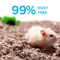 A light-colored hamster sits on carefresh Small Animal Bedding made from reclaimed paper fiber, Natural, with text above reading 99% Dust Free. A green plastic tunnel is blurred in the background.