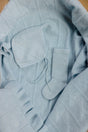 AU Baby Cashmere Cloud Baby Blanket Gift Set - Hydrangea, featuring a light blue organic cashmere baby blanket, matching bonnet, and a single sock with a textured diamond pattern.