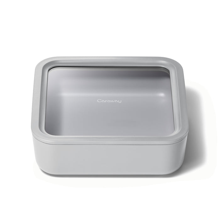 A square, light gray Caraway food storage container with rounded edges and a clear lid, shown on a white background.