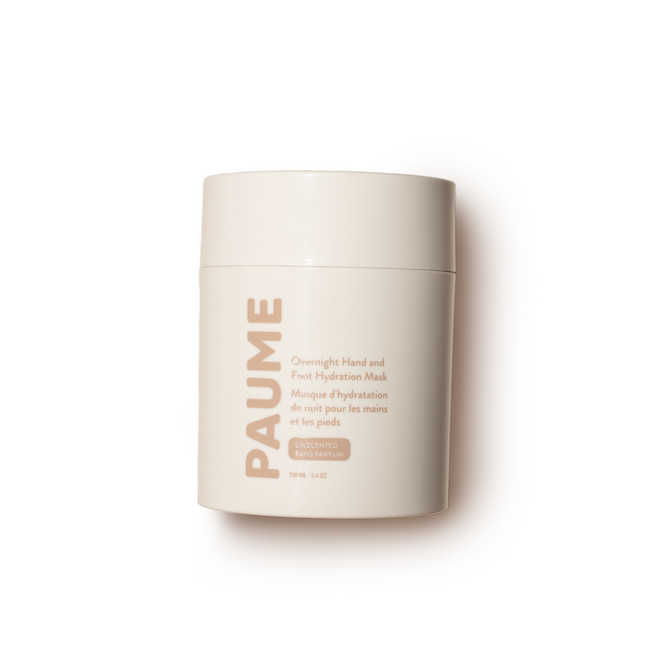 A beige cylinder container of PAUME Overnight Hand and Foot Hydration Mask enriched with glycerin features subtle brand name and product description on a white background, highlighting the simplicity and elegance of its packaging.