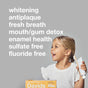 A smiling young girl holds a toothbrush and Davids Hydroxi Whitening + Enamel Health Toothpaste with nano hydroxyapatite (Kids+Adults), as benefits like natural whitening, antiplaque, fresh breath, enamel health, sulfate free, nano hydroxyapatite, and fluoride free are displayed on a grey background.