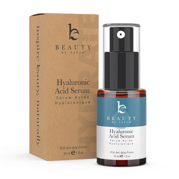 A bottle of Beauty by Earth Hyaluronic Acid Serum with a pump dispenser stands next to its brown cardboard packaging. Both display the product name and details in black text. The bottle contains 30 ml (1 fl oz).