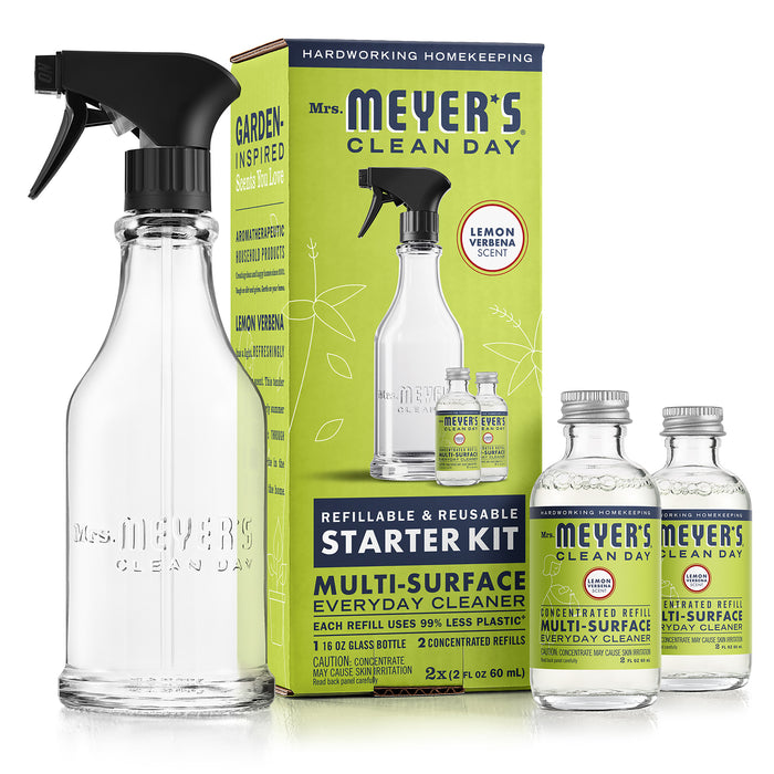 Mrs. Meyer’s Clean Day Starter Kit with a glass spray bottle, two small bottles of concentrated refill, and the product packaging featuring lemon verbena scent. The packaging highlights refillable and reusable features.