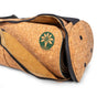 A Cork Yoga Mat Carrier by Yoloha Yoga, featuring zippers and a tan lining, partially reveals a cork yoga mat with a green tree logo inside the open bag.
