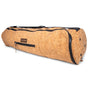 The Cork Yoga Mat Carrier by Yoloha Yoga is a cylindrical bag made from natural cork, featuring a zipper pocket, black handle, and the Yoloha Yoga brand label on the side.
