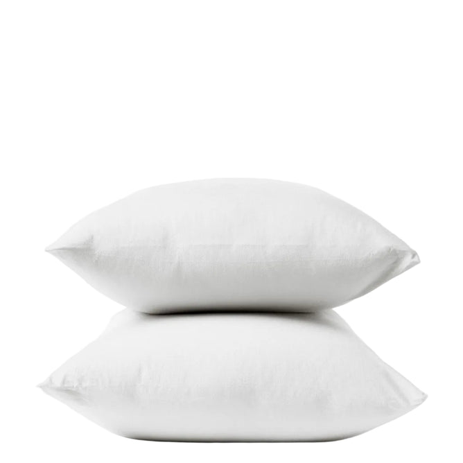 Two white pillows stacked on top of each other against a plain white background, each encased in Coyuchi’s Organic Crinkled Percale™ Pillowcases for supreme comfort.
