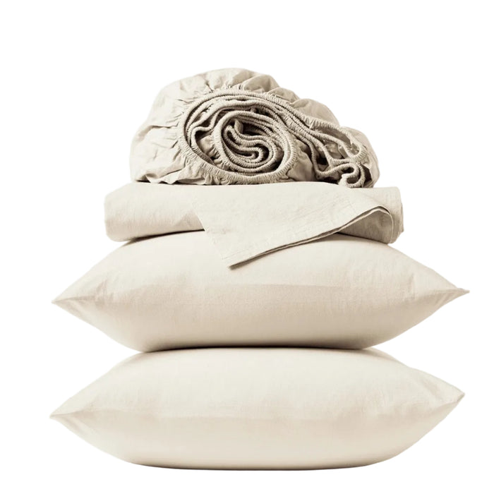 Two beige pillows are stacked atop one another, topped with a folded Coyuchi Organic Crinkled Percale™ Sheet Set and a rolled-up fitted sheet—all crafted from breathable bedding—set against a plain white background.