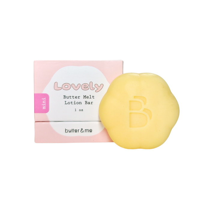 A pale yellow, flower-shaped lotion bar with a B logo is displayed next to its pink and white box labeled Lovely Butter Melt Lotion Bar 1 oz by butter & me.