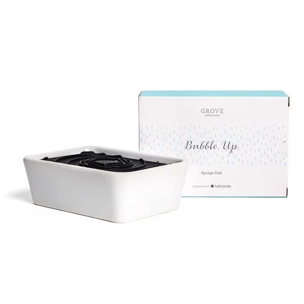 A white rectangular sponge dish with a black insert sits next to its box, labeled Grove Bubble Up Sponge Dish. The packaging is white with light blue accents and small blue raindrop patterns.