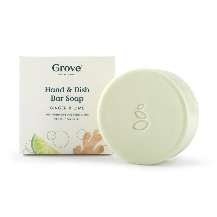 A round, pale green bar of soap with an embossed leaf design is placed in front of its box labeled Grove Collaborative Hand & Dish Bar Soap, Ginger & Lime. The box shows ginger and lime illustrations.