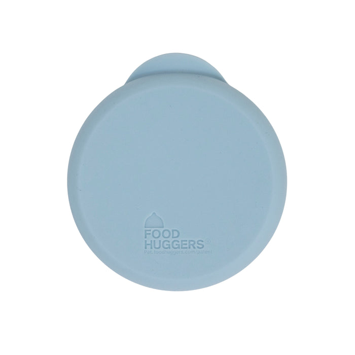 A round, light blue silicone food cover with the brand name Food Huggers printed on top, viewed from above against a white background.